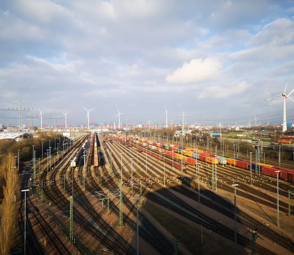 Freight yard with numerous tracks, overhead lines, and trains